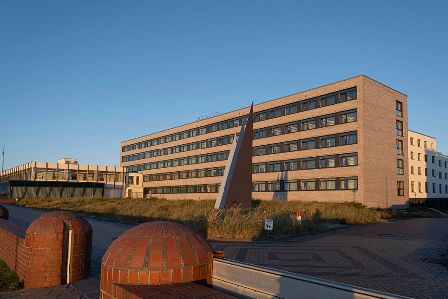 Die Klinik Norderney wird von der Abenddämmerung in oranges Licht getaucht Die Klinik Norderney wird von der Abenddämmerung in oranges Licht getaucht