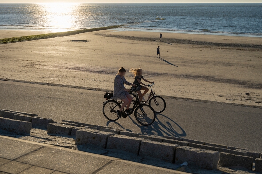 Zwei Radfahrerinen auf der Strandpromenade auf Norderney