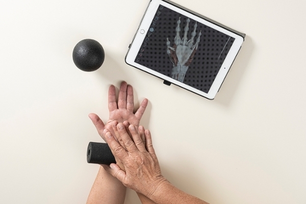 Eine Hand rollt eine kleine schwarze Rolle über eine andere Hand Eine Hand rollt eine kleine schwarze Rolle über eine andere Hand