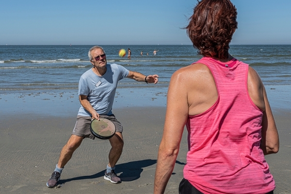 Eine Gruppe von Patientinnen und Patienten macht Sport am Strand Eine Gruppe von Patientinnen und Patienten macht Sport am Strand