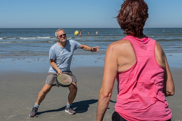Eine Gruppe von Patientinnen und Patienten macht Sport am Strand